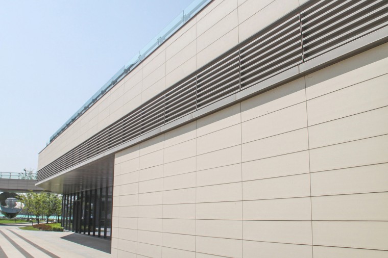 Close-up of beige Terracotta Wall Panels with subtle gray metal accents, highlighting the building's modern finish